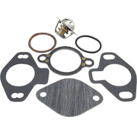 photo of JLM Marine thermostat repair kit for Mercruiser sterndrive motors, including a stainless steel thermostat with brass component, round brown gasket, black die-cut gaskets with holes, and a black o-ring